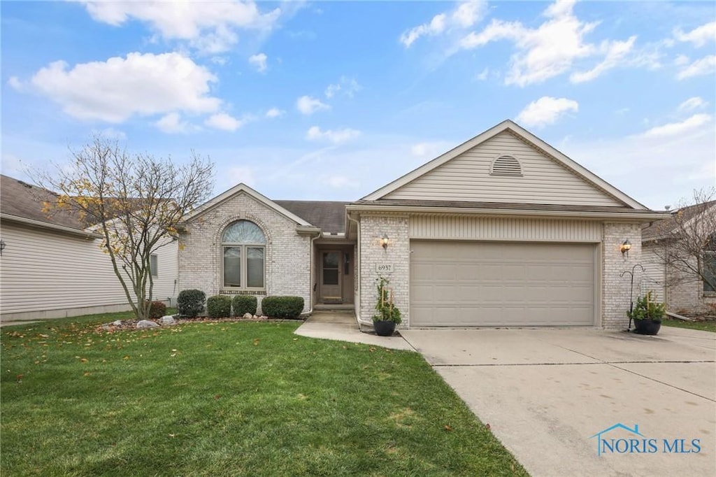 ranch-style house featuring a garage and a front yard