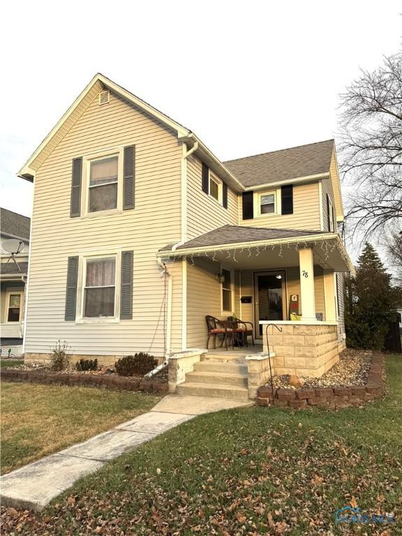 view of front of property featuring covered porch and a front yard