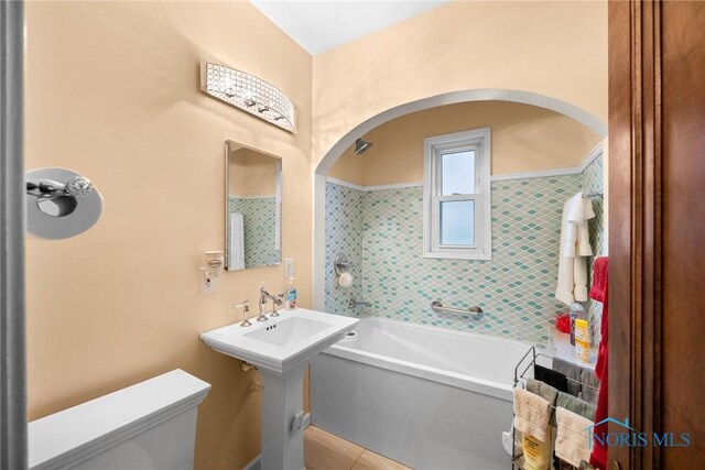 bathroom with toilet, a bathtub, and tile patterned flooring