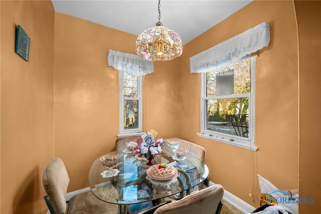 dining area featuring a wealth of natural light and an inviting chandelier