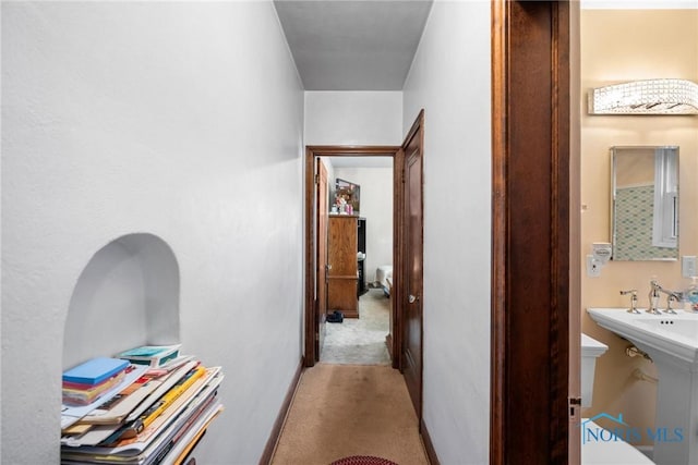 corridor featuring light colored carpet