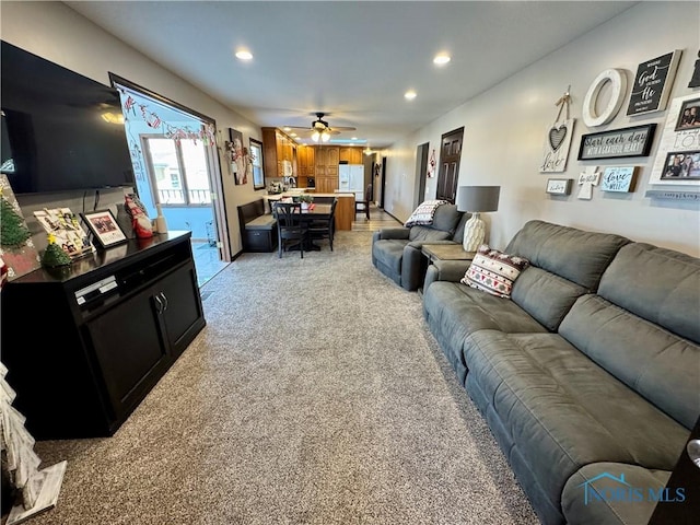 living room with ceiling fan and light colored carpet