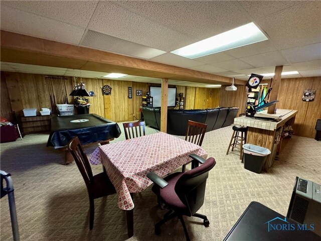 game room with a drop ceiling, wood walls, and carpet floors