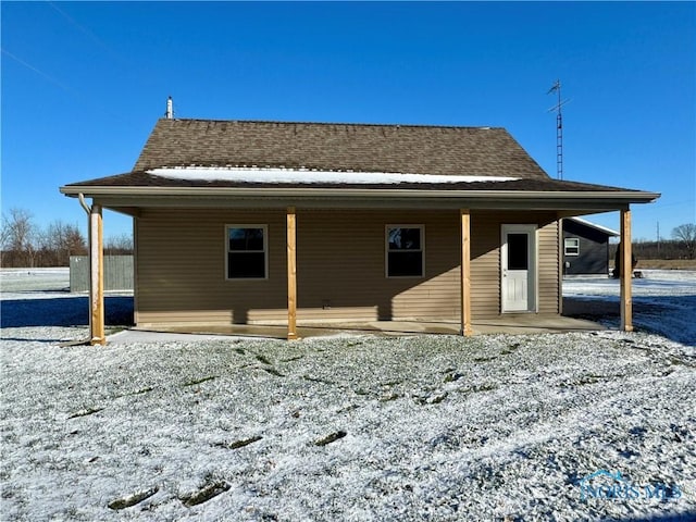 view of snow covered back of property