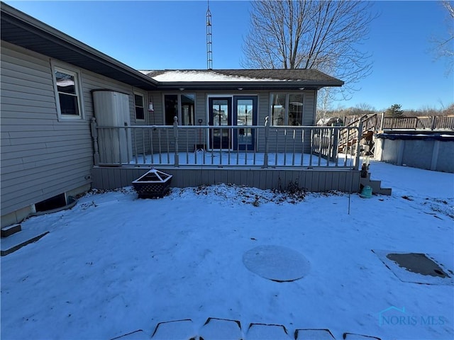 view of snow covered rear of property