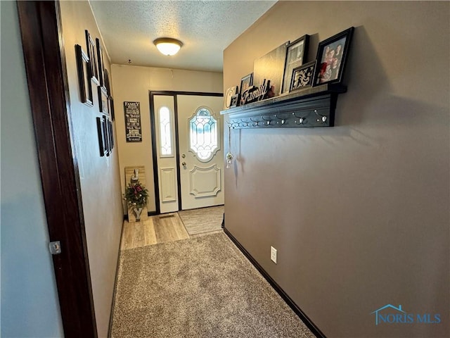 entryway with light colored carpet and a textured ceiling