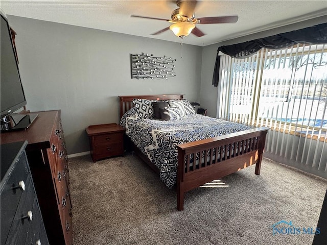 bedroom with ceiling fan, carpet floors, and a textured ceiling