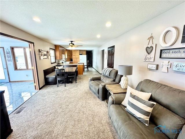 living room with a textured ceiling and ceiling fan