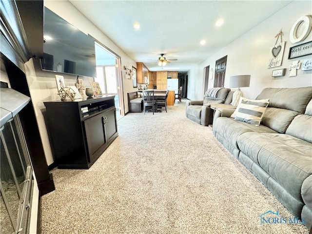 living room featuring ceiling fan and light colored carpet