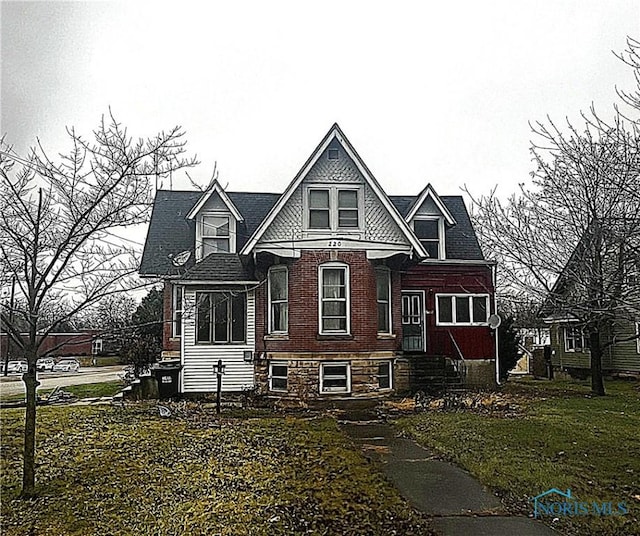 victorian home with a front lawn