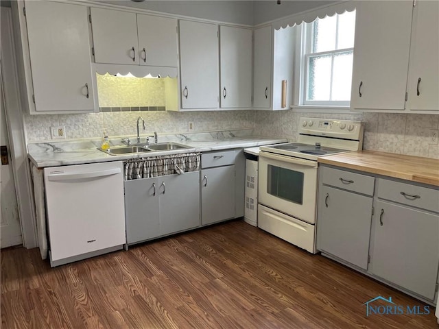 kitchen with white cabinets, dark hardwood / wood-style flooring, white appliances, and sink