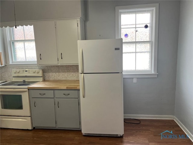 kitchen with white appliances, white cabinetry, a healthy amount of sunlight, and backsplash