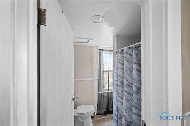 bathroom featuring hardwood / wood-style floors and toilet