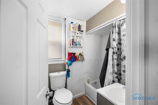 bathroom with shower / bath combo with shower curtain, hardwood / wood-style floors, and toilet