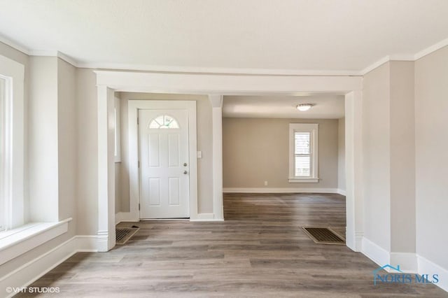 entryway with hardwood / wood-style floors and ornamental molding