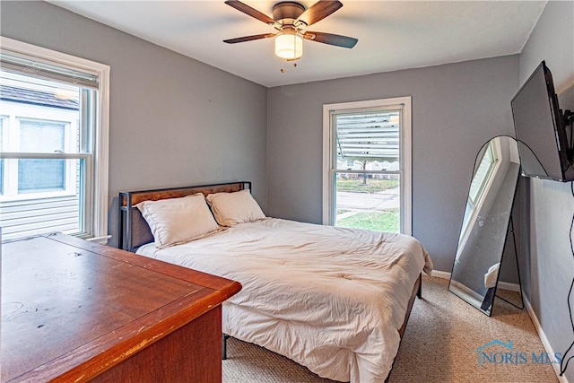 bedroom with ceiling fan, carpet floors, and multiple windows