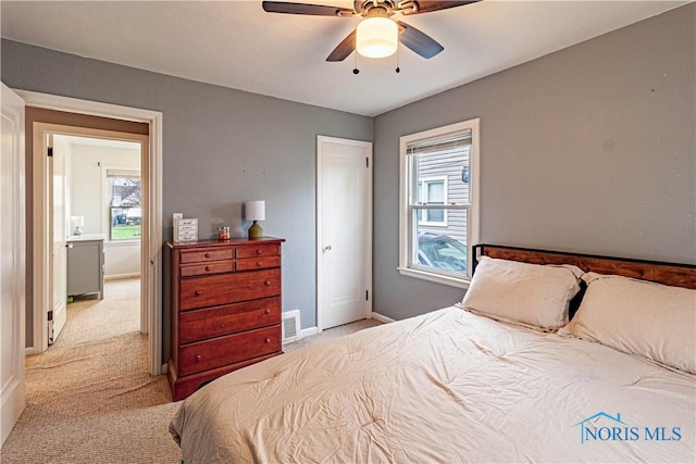 carpeted bedroom with multiple windows and ceiling fan