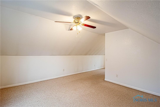 bonus room featuring a textured ceiling, carpet floors, ceiling fan, and lofted ceiling