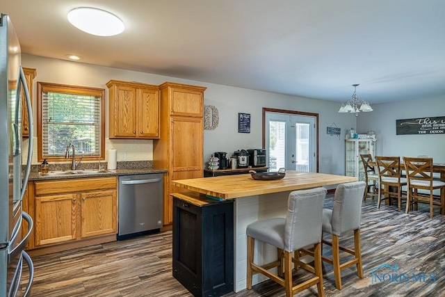 kitchen with a healthy amount of sunlight, butcher block counters, sink, and appliances with stainless steel finishes