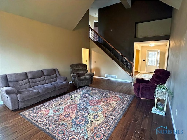 living room featuring high vaulted ceiling and dark hardwood / wood-style floors