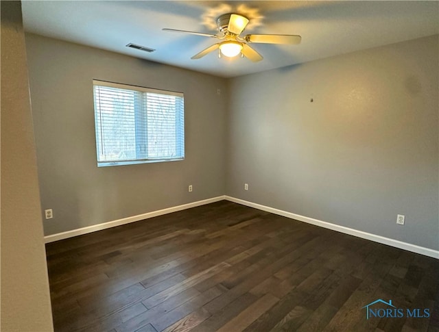 empty room with dark hardwood / wood-style flooring and ceiling fan