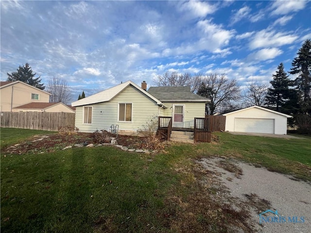 view of front of property featuring a garage, an outbuilding, and a front yard