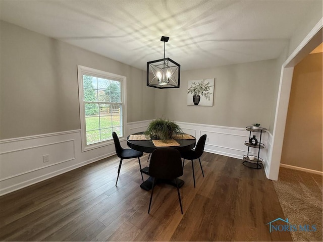 dining room with dark wood-type flooring and a chandelier