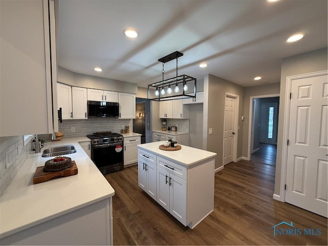 kitchen featuring dark wood-type flooring, white cabinets, sink, a kitchen island, and stainless steel appliances