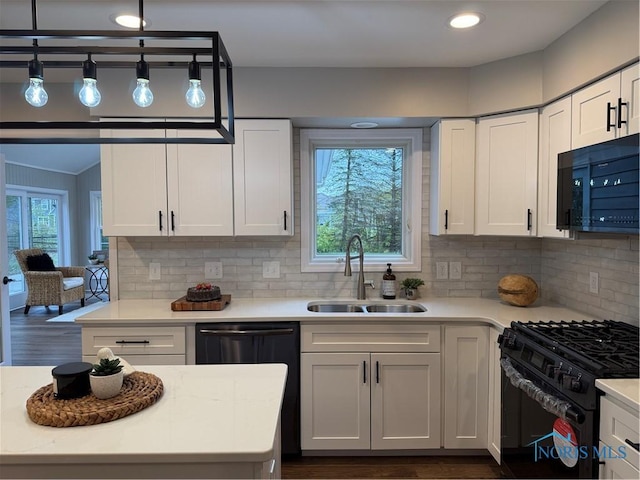 kitchen featuring sink, tasteful backsplash, pendant lighting, white cabinets, and black appliances