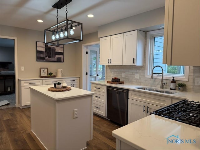 kitchen featuring a center island, sink, dark hardwood / wood-style flooring, stainless steel dishwasher, and white cabinets