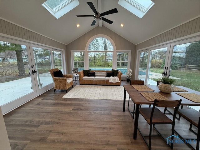 sunroom / solarium with ceiling fan, french doors, and vaulted ceiling with skylight