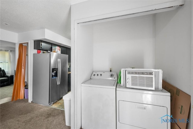 clothes washing area with independent washer and dryer, carpet floors, and a textured ceiling