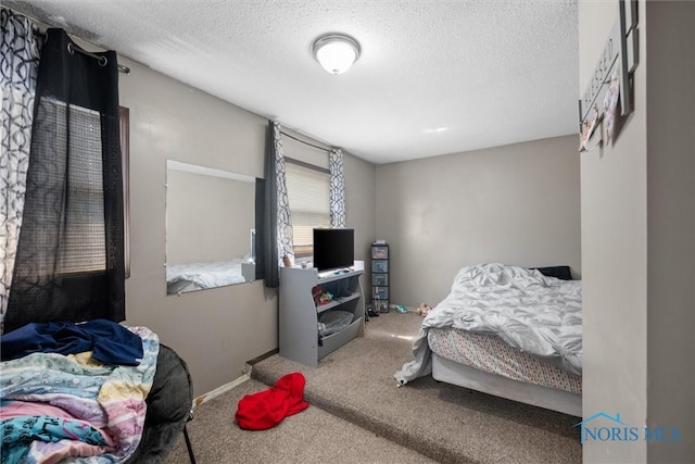 bedroom featuring carpet floors and a textured ceiling