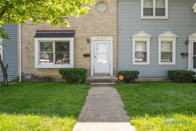 doorway to property with a lawn