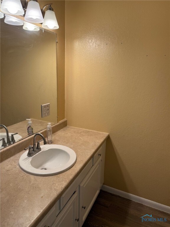 4127 Burnham Ave, Toledo, OH 43612 - bathroom featuring wood finished floors, vanity, and baseboards