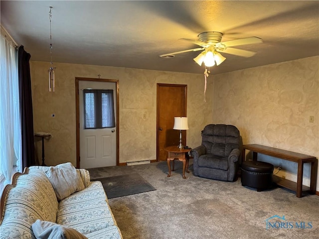 living room with ceiling fan, carpet floors, and a baseboard heating unit