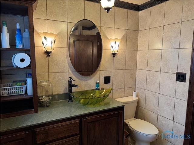 bathroom with vanity, tile walls, and toilet