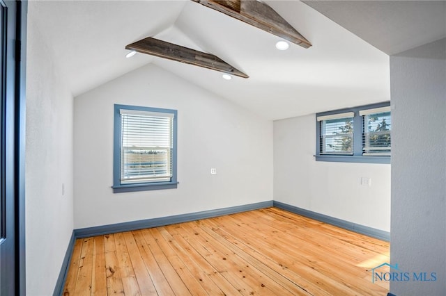 spare room featuring hardwood / wood-style floors and lofted ceiling with beams