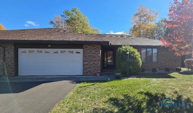 ranch-style home with a garage and a front lawn