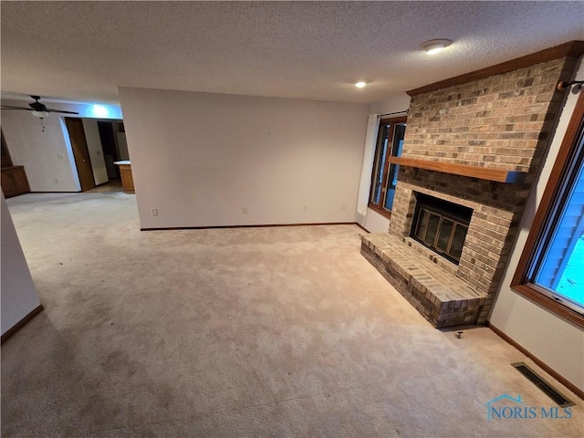 unfurnished living room featuring a fireplace, ceiling fan, light colored carpet, and a textured ceiling