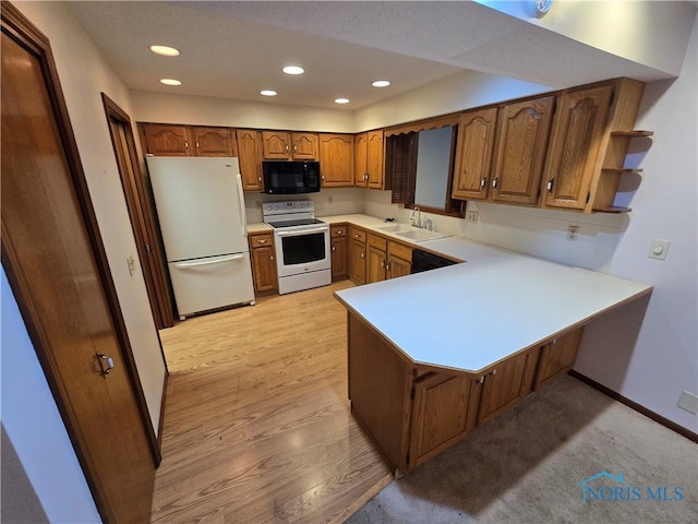 kitchen featuring kitchen peninsula, white appliances, light hardwood / wood-style flooring, and sink