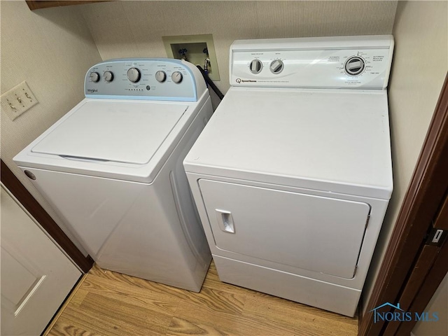 washroom featuring washing machine and clothes dryer and light wood-type flooring