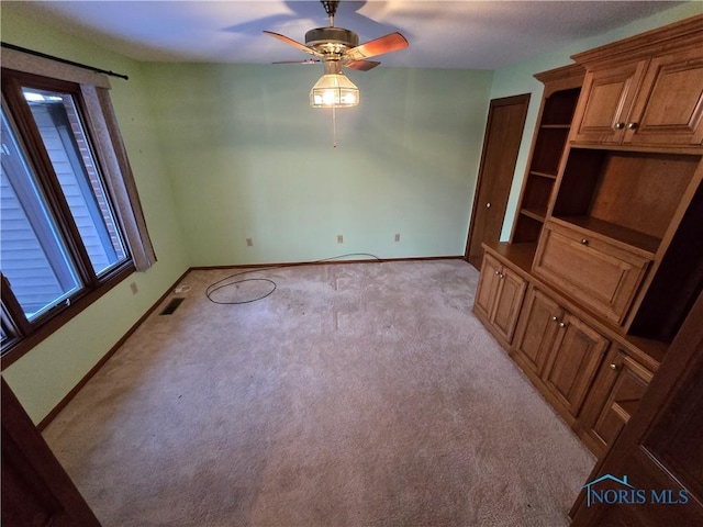 carpeted empty room featuring ceiling fan