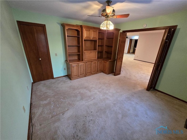 unfurnished living room with ceiling fan and light colored carpet