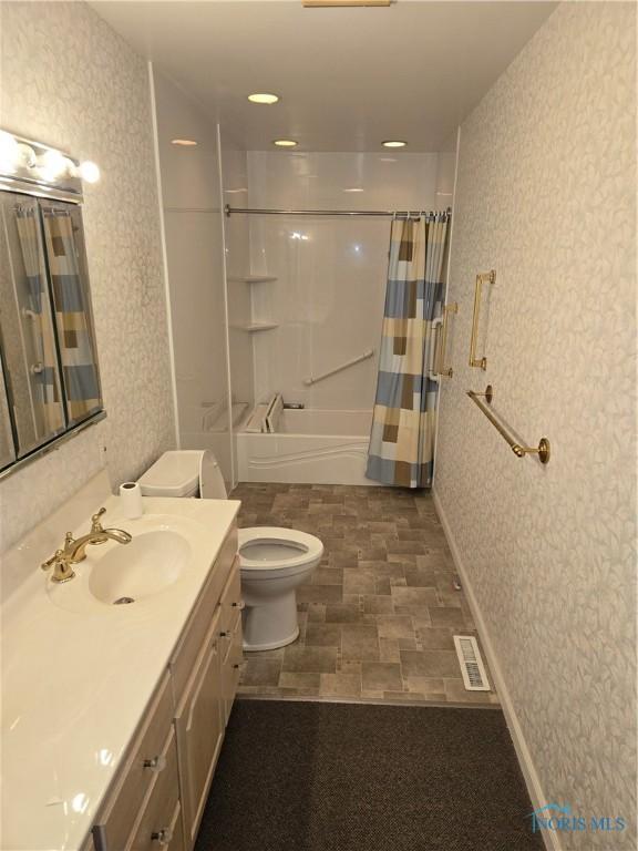 full bathroom with shower / tub combo with curtain, vanity, and toilet