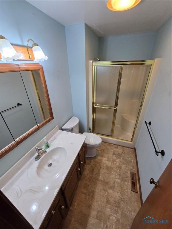 bathroom with vanity, toilet, and walk in shower