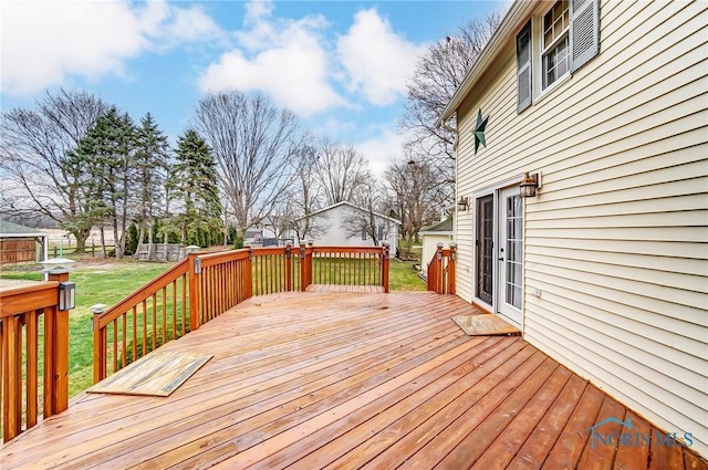 wooden terrace featuring a yard