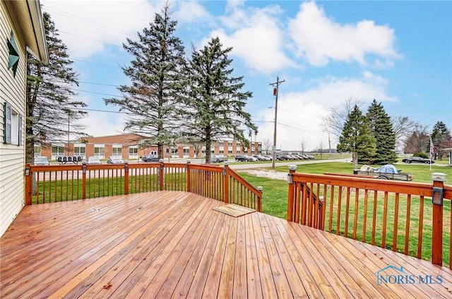 wooden deck featuring a lawn