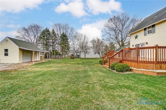 view of yard featuring a garage, an outdoor structure, and a deck