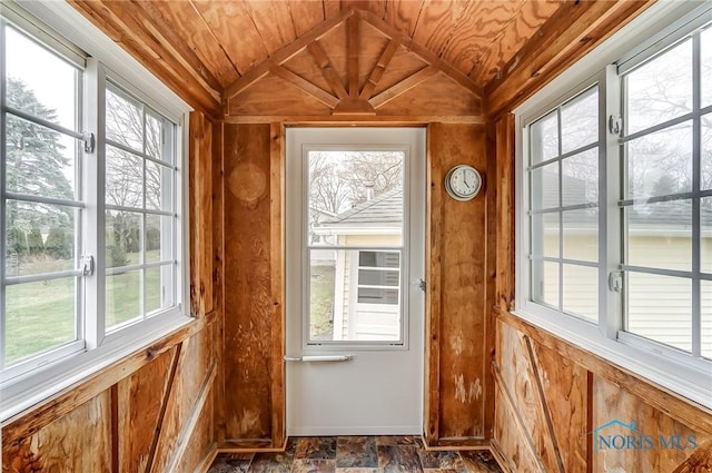 entryway with wood walls, wood ceiling, and vaulted ceiling